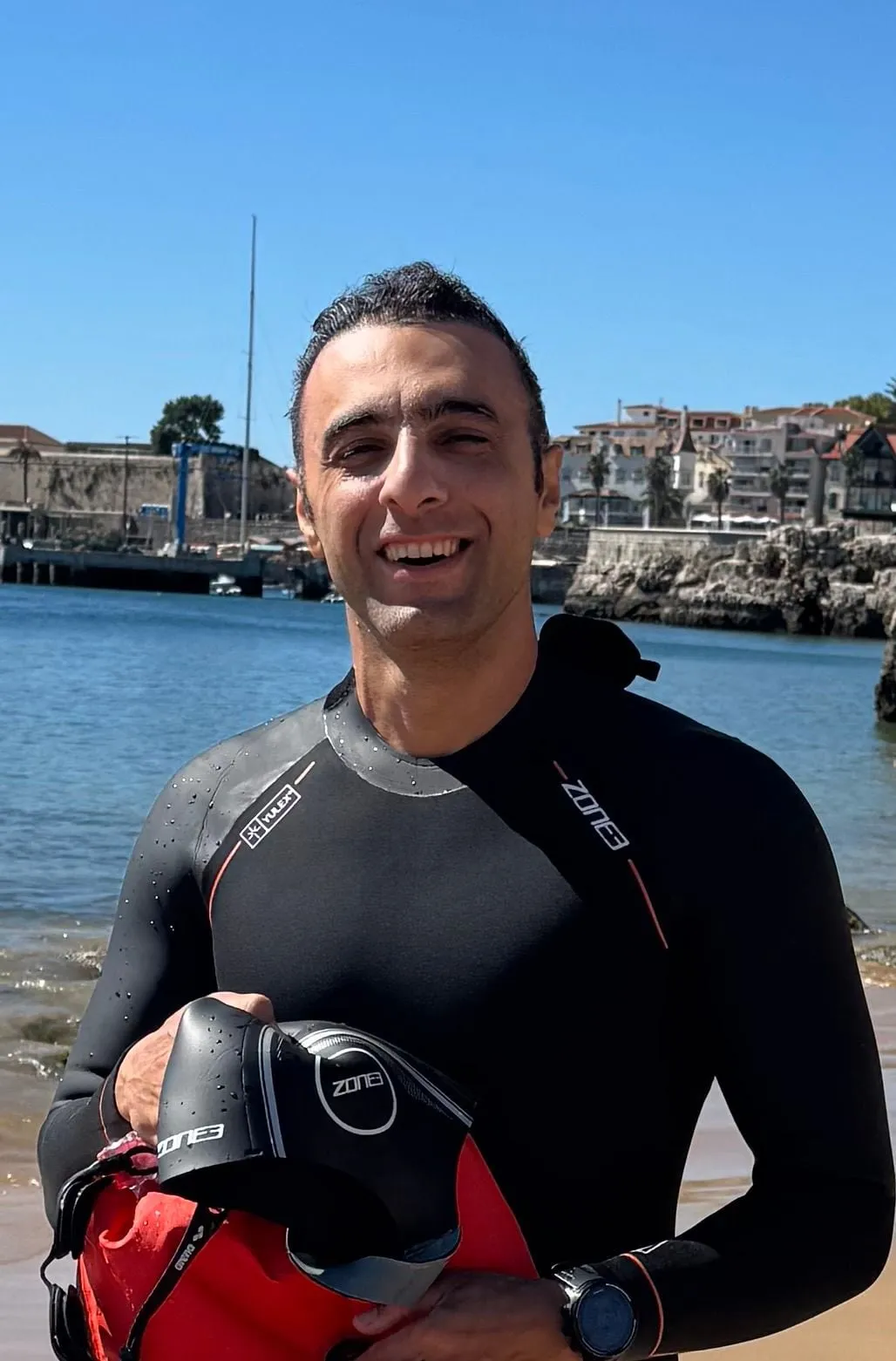 Shahin in a wetsuit on the beach after an open-water swim