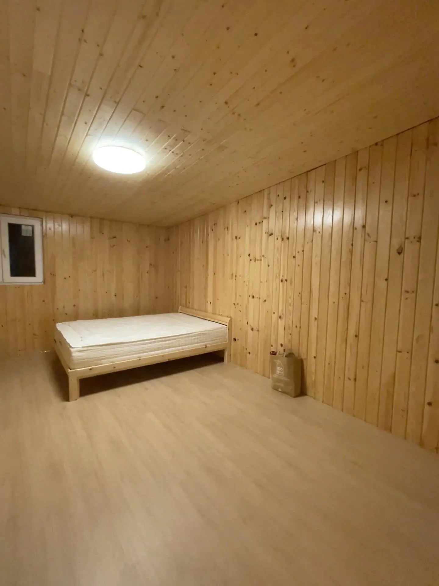 A bedroom fully clad in pine boards